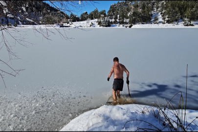 Uludağ'ın buz tutan göllerine girerek soğuk suyun keyfini çıkarıyor